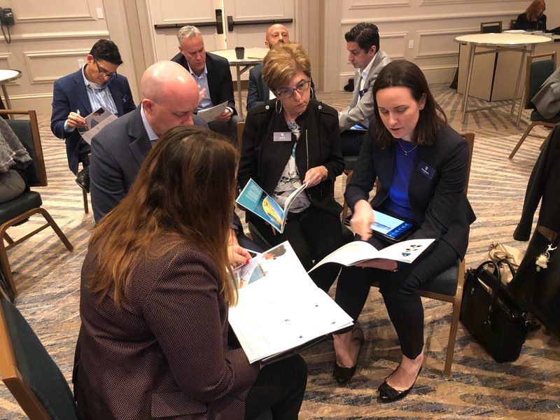 Royal Caribbean Group workshop with participants reviewing learning materials together